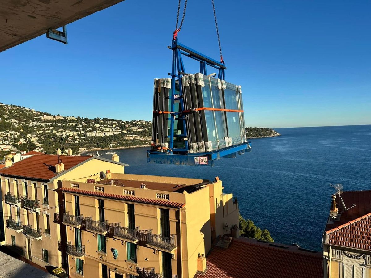 Vetrate sollevate con la gru in un cantiere affacciato sul mare